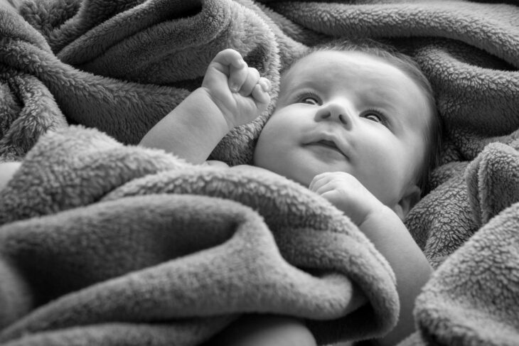 black and white photo of cosy baby